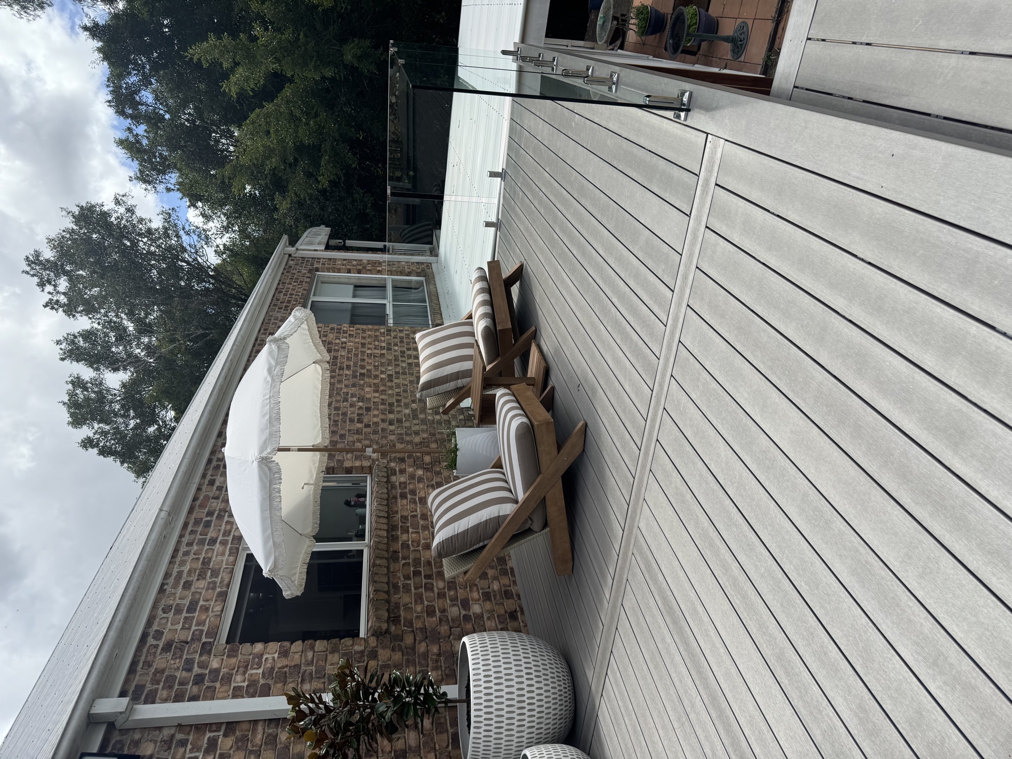 Composite deck with umbrella and outdoor lounge chairs