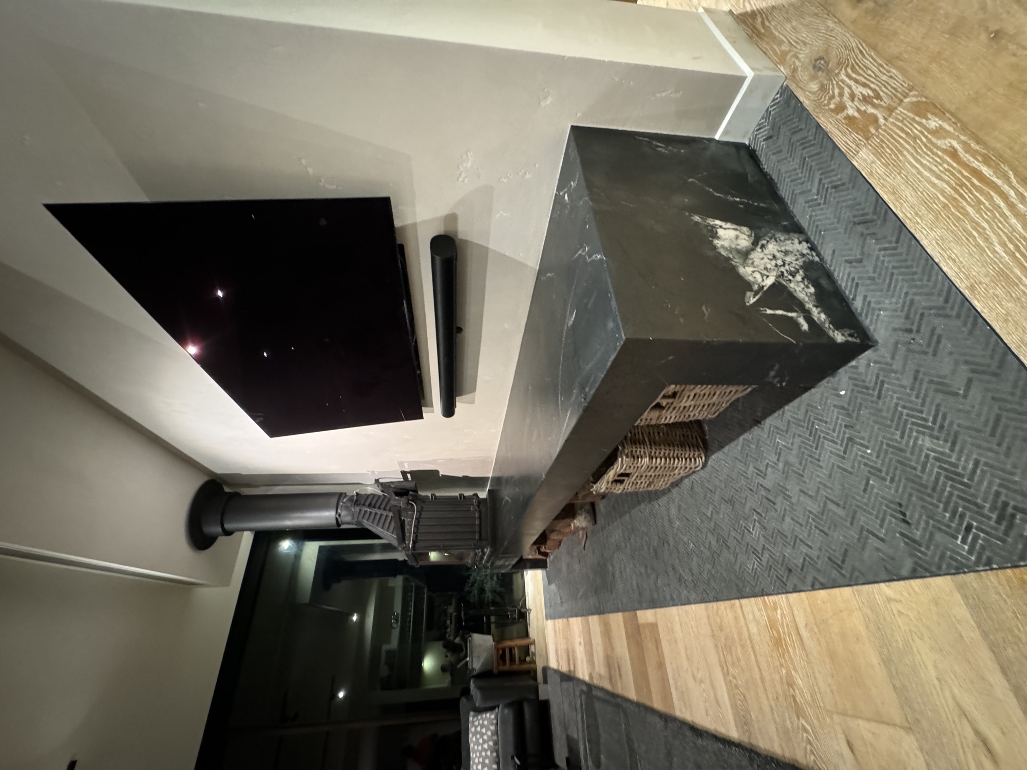 Stone plinth with wall-mounted TV and integrated baskets