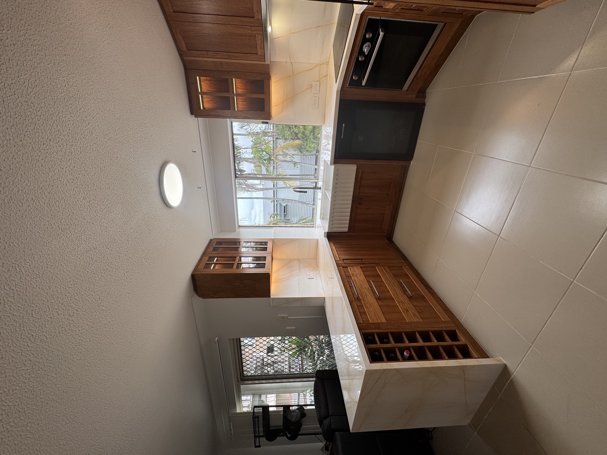 Butler pantry with marble splashback and walnut cabinets