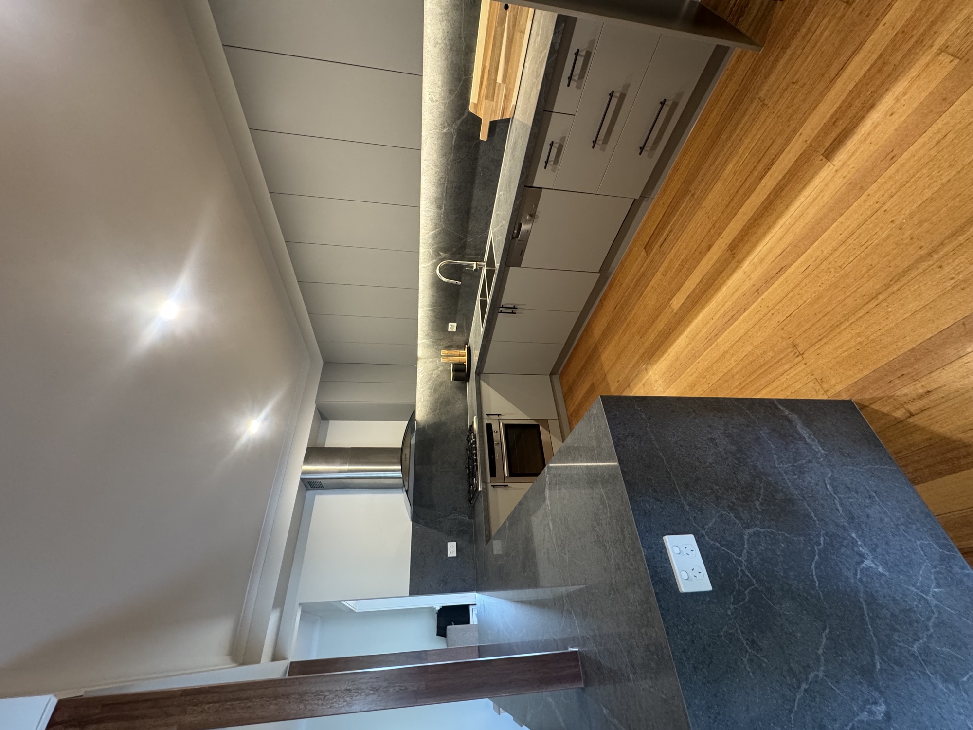 Veined stone island with brushed stainless rangehood