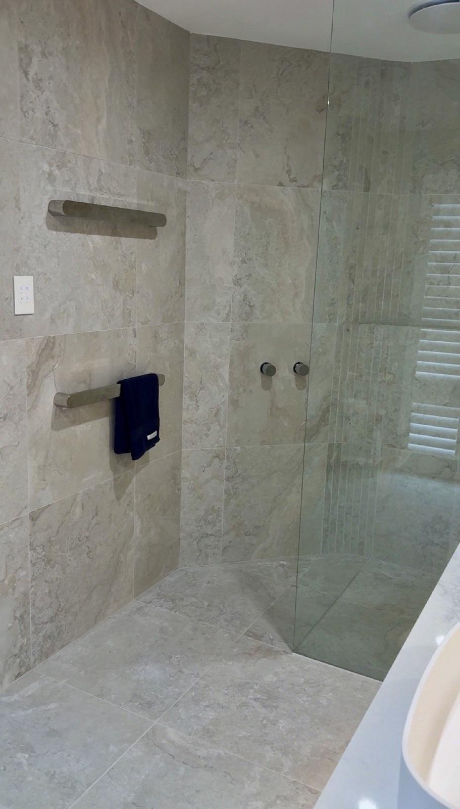 Heated towel rail beside a walk-in shower